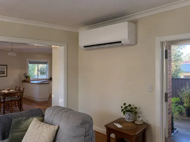 Clean split system mounted high on a living room wall in a home with open louvre in Prospect